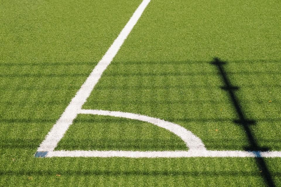 Close-up van de witte hoeklijn op een groen kunstgrasveld